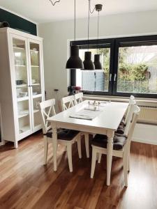 a dining room with a white table and chairs at *TOP*+Allgäu*Familie*NETFLIX*mit Garten & *PS4* in Kaufbeuren