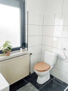 e bagno con servizi igienici e sedile in legno. di *TOP*+Allgäu*Familie*NETFLIX*mit Garten & *PS4* a Kaufbeuren