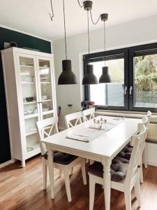 uma sala de jantar com uma mesa branca e cadeiras em *TOP*+Allgäu*Familie*NETFLIX*mit Garten & *PS4* em Kaufbeuren
