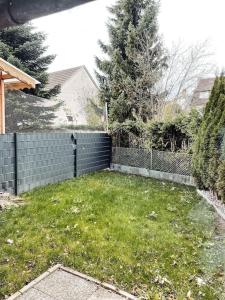 a backyard with a fence and a yard with grass at *TOP*+Allgäu*Familie*NETFLIX*mit Garten & *PS4* in Kaufbeuren