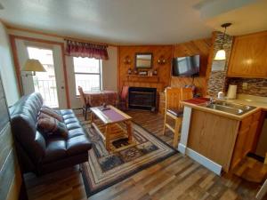 a living room with a couch and a table and a kitchen at Alex's Cozy STUDIO with Pool and Sauna in Brian Head