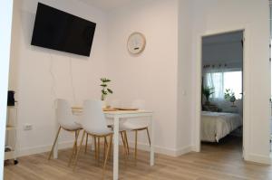 a dining room with a white table and white chairs at Rosamar 211 Los Cristianos Ocean Views in Arona