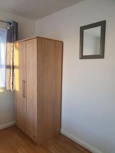 a wooden cabinet in the corner of a room at Lovely 2-Bedroom Condo With indoor Fire Place in London