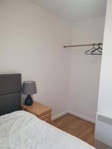 a bedroom with a bed and a table with a lamp at Lovely 2-Bedroom Condo With indoor Fire Place in London