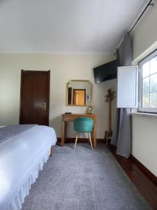 1 dormitorio con cama, escritorio y espejo en THE RIVER HOUSE - Termas Guesthouse en Termas de Sao Pedro do Sul