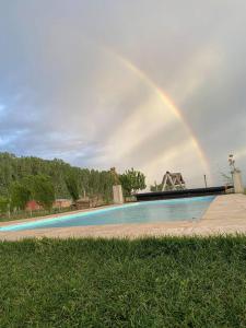 un arco iris en el cielo sobre una piscina en Cabaña Merlot - Malbec en La Consulta