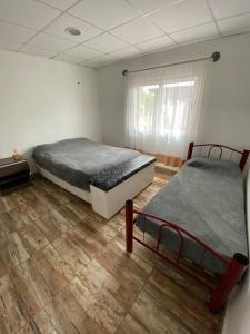 1 dormitorio con 2 camas y suelo de madera en Cabaña Merlot - Malbec en La Consulta