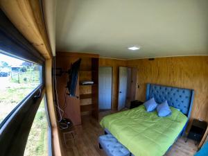 een slaapkamer in een camper met een bed en een televisie bij Cabaña Nueva en Ancud Chiloe in Ancud
