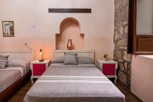 a bedroom with two beds and two night stands at Hotel Cantera Rosa in Morelia
