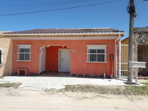 una casa roja con una puerta blanca en Madreselva en Chuí