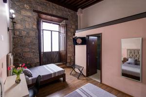 a bedroom with a bed and a mirror at Hotel Cantera Rosa in Morelia