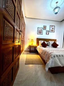 a bedroom with a bed and a large wooden wall at Cosy appartement au cœur de Gueliz in Marrakesh