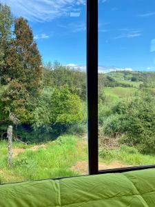 - une vue sur un champ depuis une fenêtre dans l'établissement Cabaña Nueva en Ancud Chiloe, à Ancud