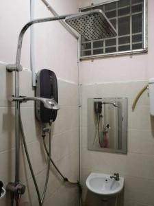 a bathroom with a shower and a sink at SRI WANG HOMESTAY @ ARAU in Arau