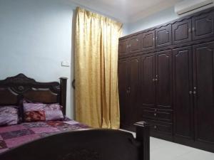 a bedroom with a bed and a dresser and a window at SRI WANG HOMESTAY @ ARAU in Arau