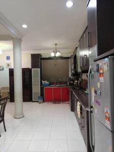 a kitchen with a refrigerator and a counter top at SRI WANG HOMESTAY @ ARAU in Arau