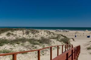 a sandy beach with a wooden path to the beach at On the Half Shell in Port Aransas