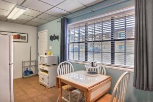 a kitchen with a table and chairs and a refrigerator at On the Half Shell in Port Aransas