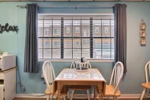 a table and chairs in a room with a window at On the Half Shell - Condo in Port Aransas