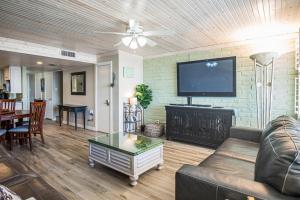 a living room with a couch and a flat screen tv at Pearl- Marlin in Port Aransas