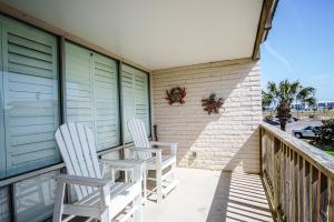 zwei weiße Stühle auf einem Balkon in der Unterkunft Pearl- Marlin in Port Aransas