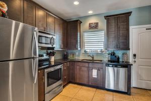 a kitchen with wooden cabinets and a stainless steel refrigerator at Sweet Retreat in Port Aransas