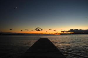 a dock in the water with the sunset in the background at HOSTEL perch in Sado