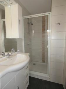 a white bathroom with a sink and a shower at Hotel Yel in Ludwigshafen am Rhein