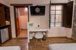 a room with a table and a chair and a bathroom at Hotel Cantera Rosa in Morelia