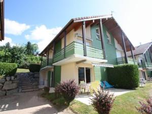 a green and white house with a yard at Appartement avec Terrasse & Piscine Privée, Gérardmer - FR-1-589-56 in Gérardmer