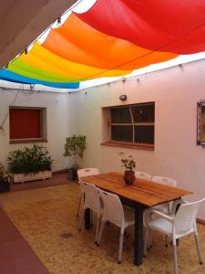 mate! Hostel في قرطبة: طاولة وكراسي تحت مظلة ملونة