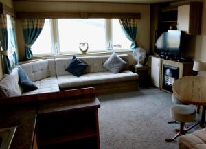 a living room with a couch and a large window at Devon Cliffs Holiday Park - Haven, 3 Bed - ABI Horizon - Wi Fi in Exmouth