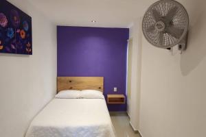 a bedroom with a white bed and a fan at Morado Departamento 42 m2 CIVAC,NISSAN Y WALMART. in Jiutepec