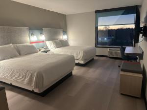 une chambre d'hôtel avec deux lits et une fenêtre dans l'établissement AVID Hotels - Fort Wayne North by IHG, à Fort Wayne