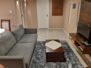 - un salon avec un canapé et une table basse dans l'établissement Rifugio del Camino - Chalé Completo, à Gramado