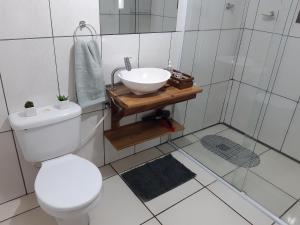 y baño con aseo blanco y lavamanos. en Rifugio del Camino - Chalé Completo en Gramado
