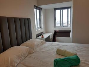 Encantador apartamento en Miraflores في ليما: غرفة نوم عليها سرير ومخدة خضراء