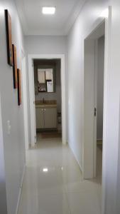 a white hallway with a kitchen in a house at APARTAMENTO NOVO E COMPLETO in Piratuba