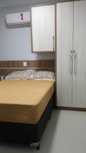 a small room with a bed and a white cabinet at APARTAMENTO NOVO E COMPLETO in Piratuba
