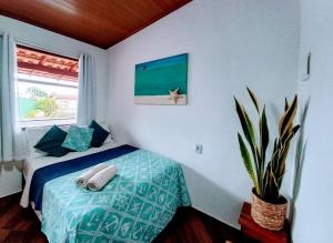 阿布拉昂的住宿－Suites Casa Azul-Vila do Abraão- conforto, limpeza, ótima localização，一间卧室配有一张床和盆栽植物