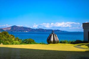 a large shell sitting on top of a field with the ocean at TAOYA Shima in Toba