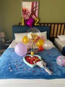 een bed met ballonnen en een bord eten erop bij Relax At Gold Coast Morib in Banting