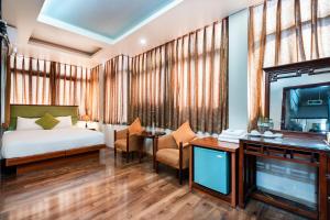 a hotel room with a bed and a tv at Artisan Lakeview Hotel in Hanoi