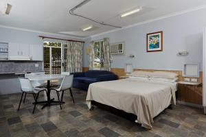 a kitchen with a bed, table and a refrigerator at Ingenia Holidays Hunter Valley in Cessnock