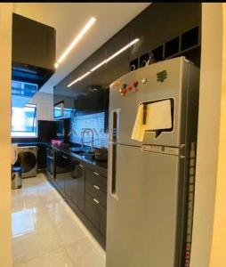 uma cozinha com um frigorífico de aço inoxidável com papel em Apt. encantador 50m da praia de Ponta Verde em Maceió