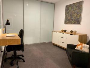 Central Canberra City apartment with study and full amenities including parking في كانبرا: مكتب فيه مكتب وكرسي ومكتب