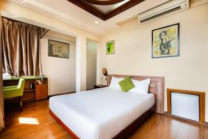 una camera da letto con un grande letto bianco e una finestra di Hanoi Old Quarter Hotel a Hanoi