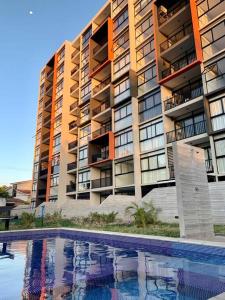 a large apartment building with a swimming pool in front of it at Avitat Joy Finest 1Brm Studio Great View Pool&Gym in San Salvador