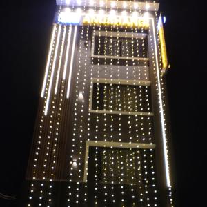 a tall building with lights on it at night at Anushangi Hotel in Hisār