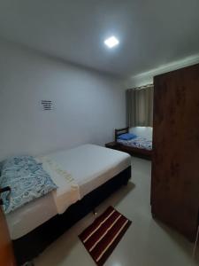 カラグアタトゥーバにあるMassaguaçu Cocanha "150 mts Praia "のベッドルーム1室(ベッド1台付)、ドア(ラグ付)